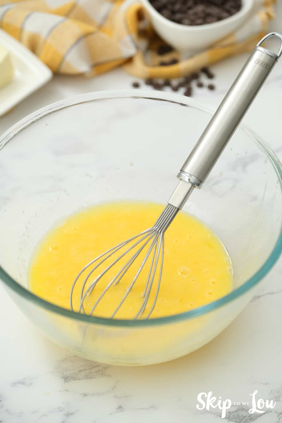 Mix eggs into butter for your chocolate chip cookie bars.