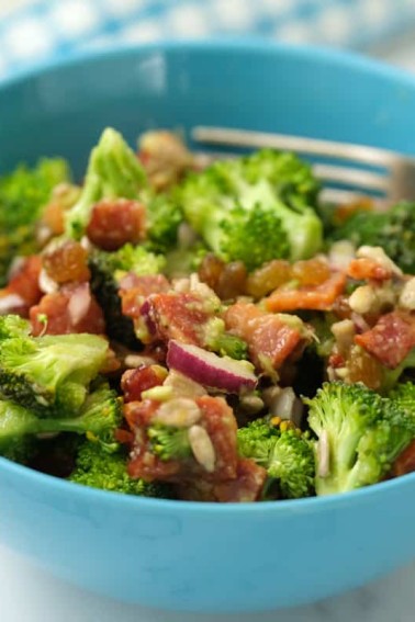 Healthy Broccoli Salad ready to eat served in a blue bowl with fork