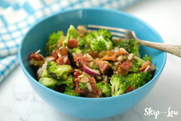 Healthy Broccoli Salad ready to eat served in a blue bowl with fork