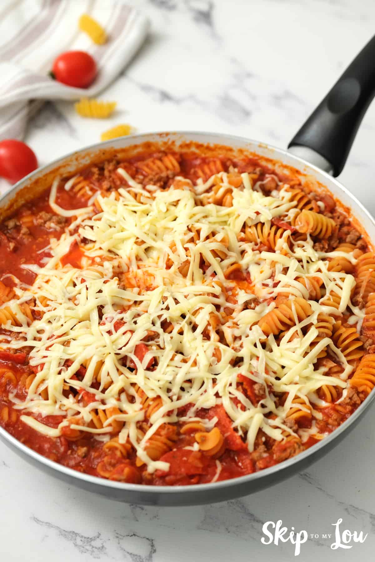 One Pot Pizza Pasta finished in skillet with cheese on top.