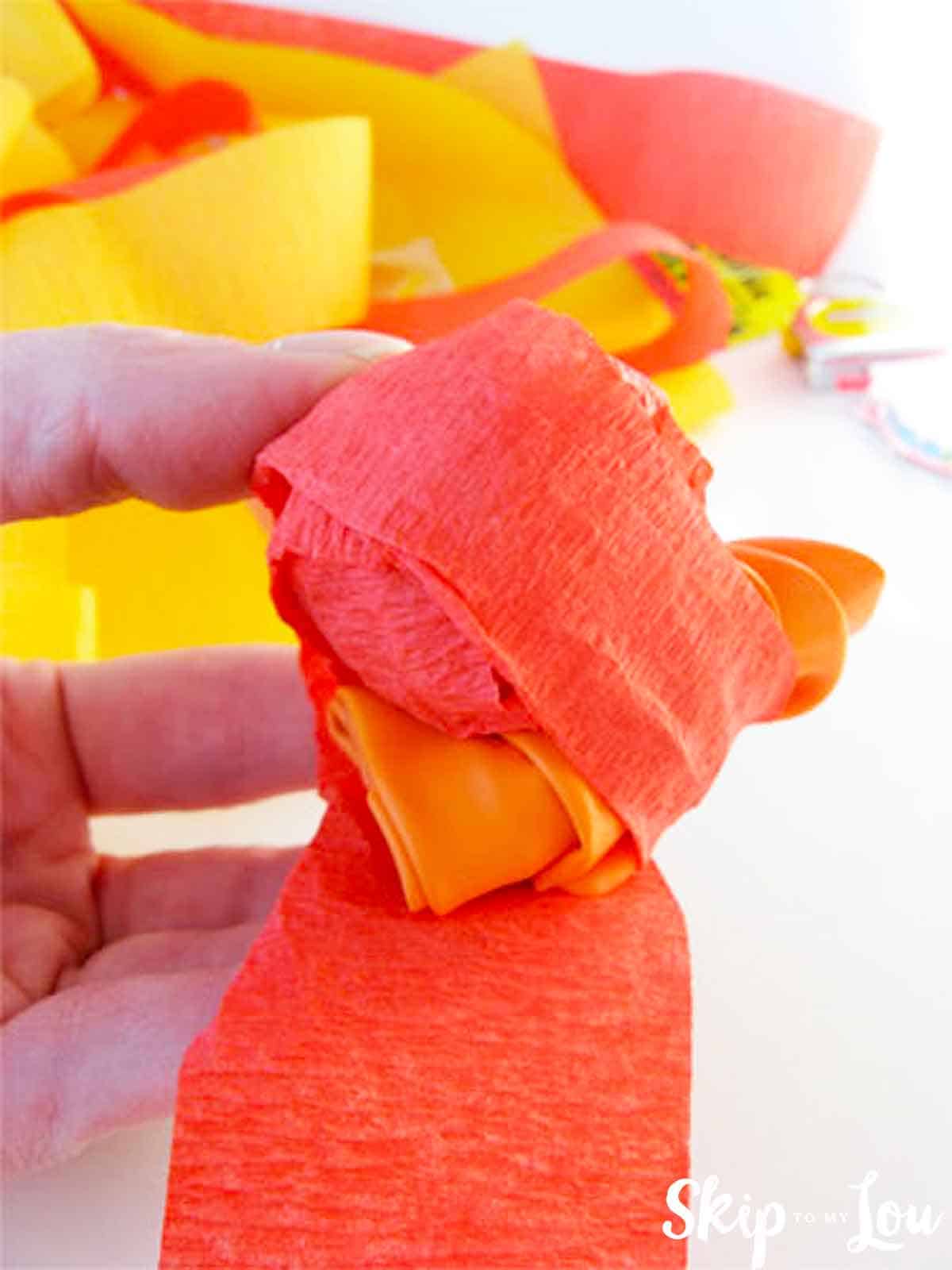 wrapping crepe paper around small trinkets to make surprise ball
