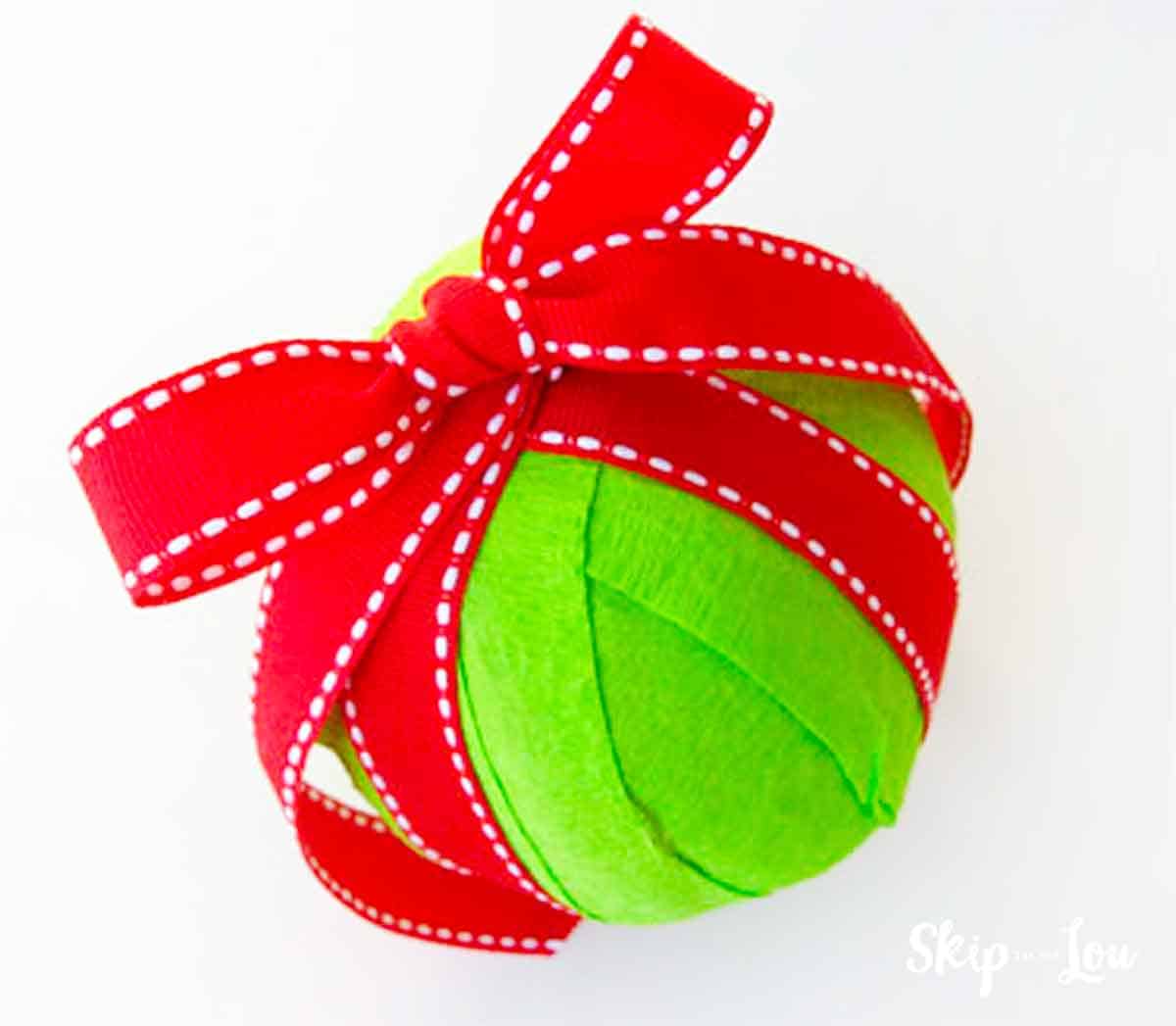 Green surprise ball with a red ribbon