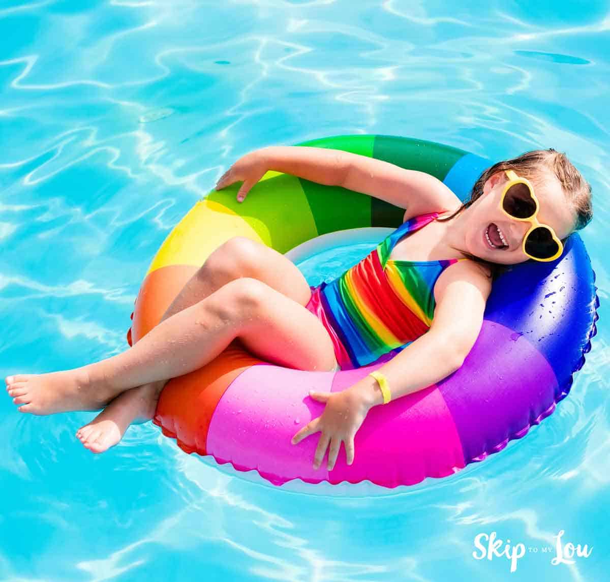 girl in rainbow water toy smiling water jokes 