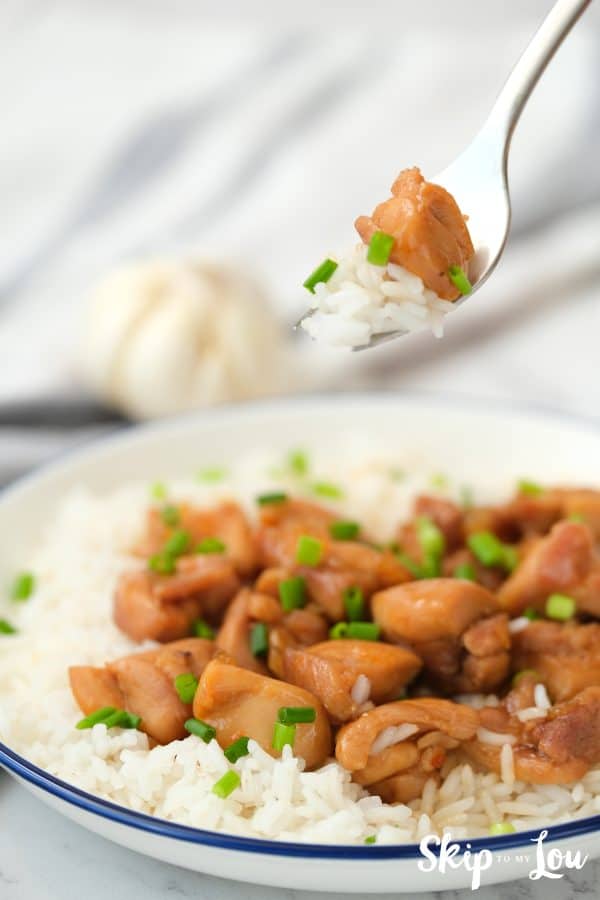 A bite of honey bourbon chicken served on rice.