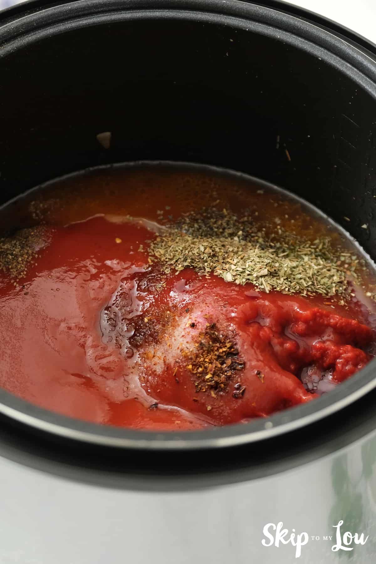 Seasonings, water, and tomato sauce stirred into ground beef for the Spaghetti Sauce.