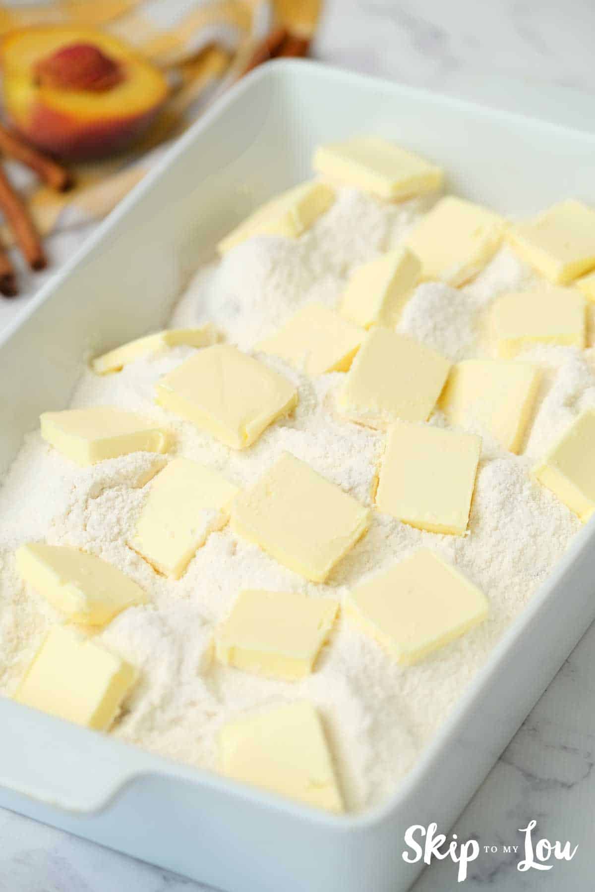 cake mix and pats of butter on top of peaches