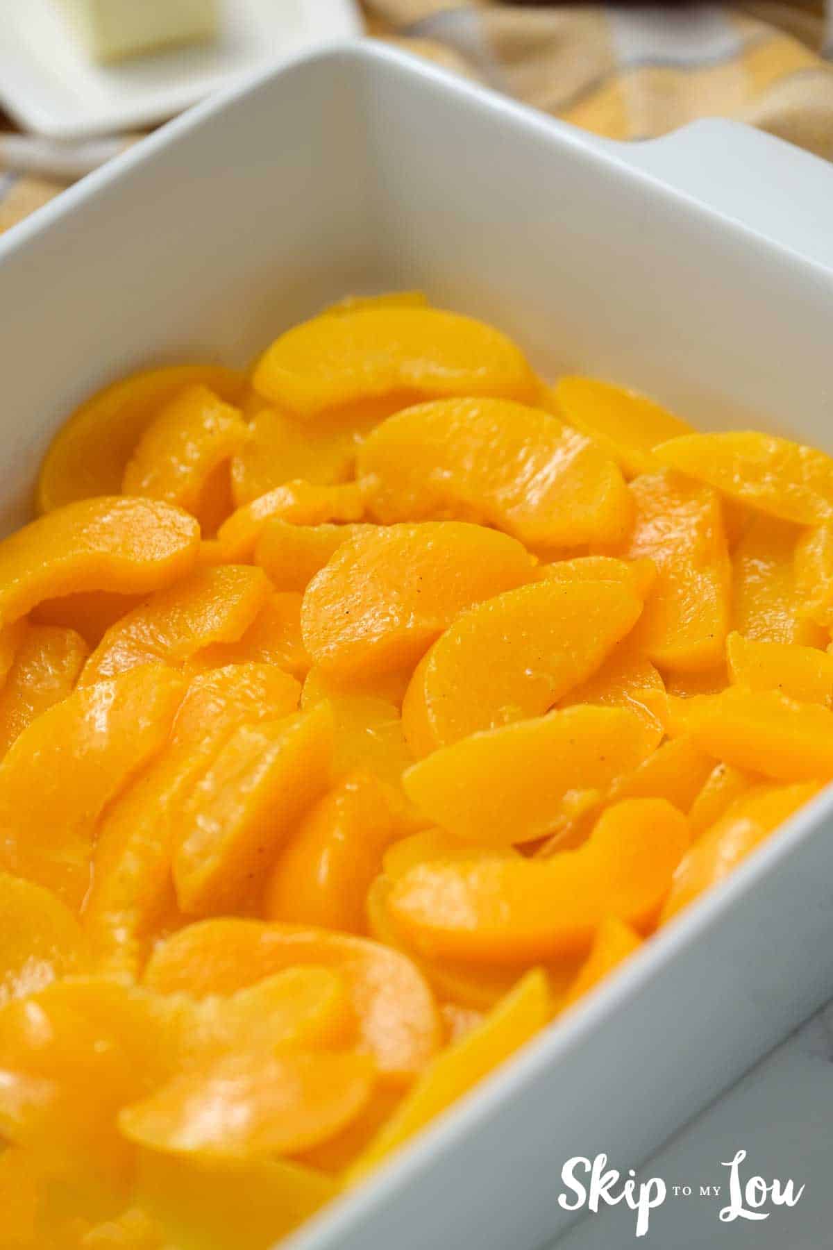 sliced peaches in baking dish