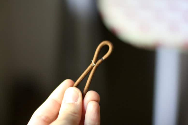 Thread knotted on hair elastic with one small and one large loop