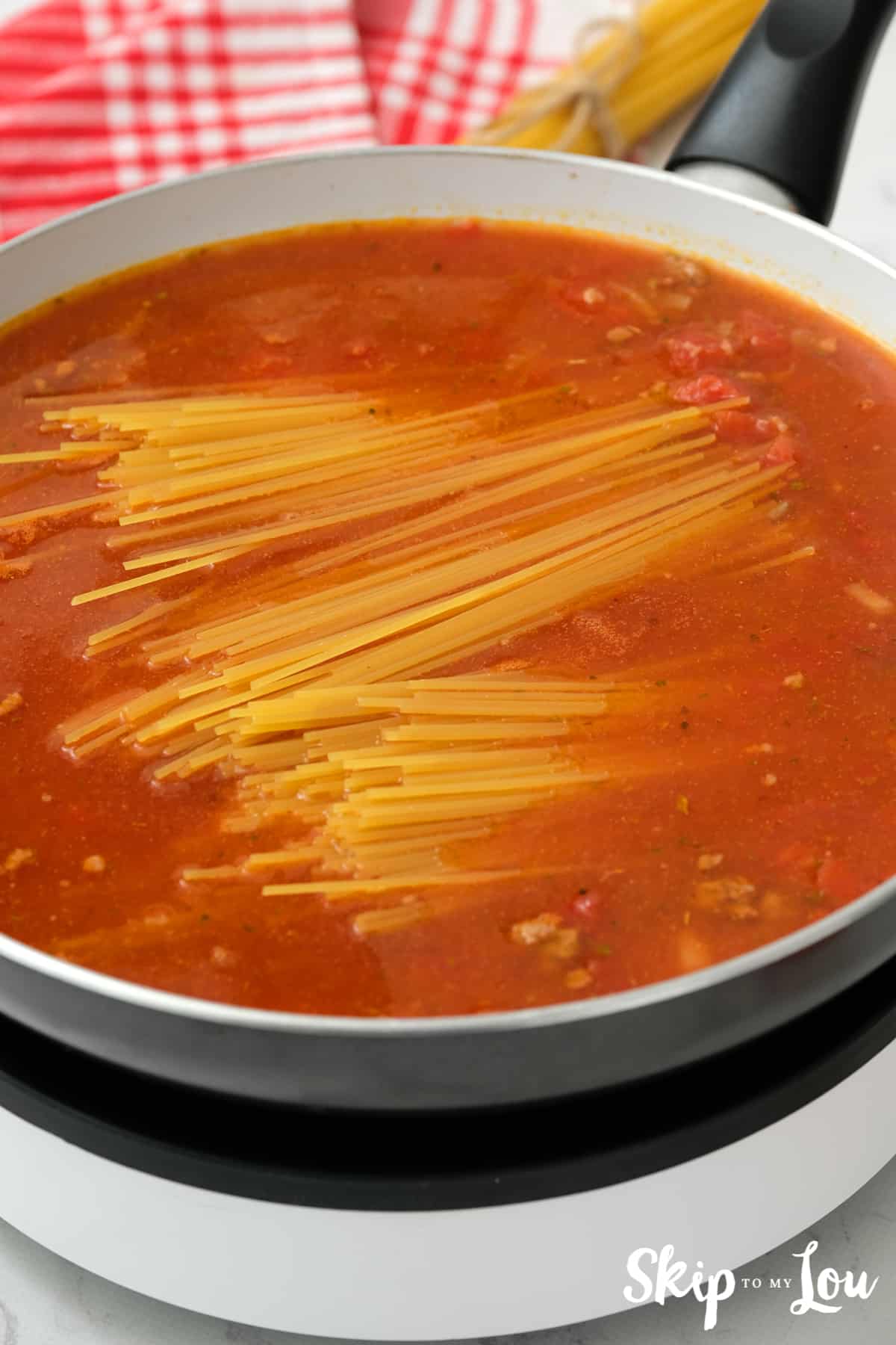 Break spaghetti in half to stir into the sauce for the Mexican Spaghetti.