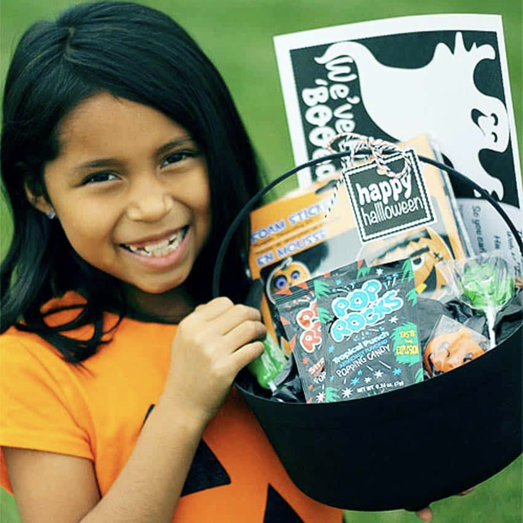 child holding plastic cauldron filled with treats and
You’ve Been Booed Printable Set with Signs and Tags