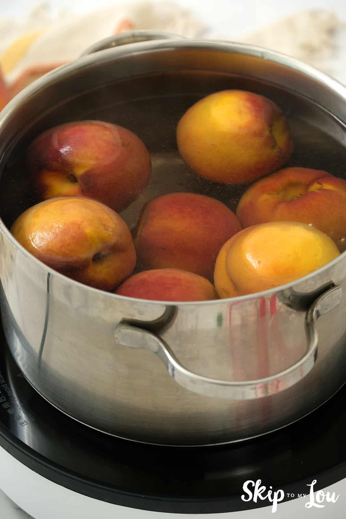 Peaches in a large pot covered with water to prepare them for chopping for the Peach Salsa Recipe.