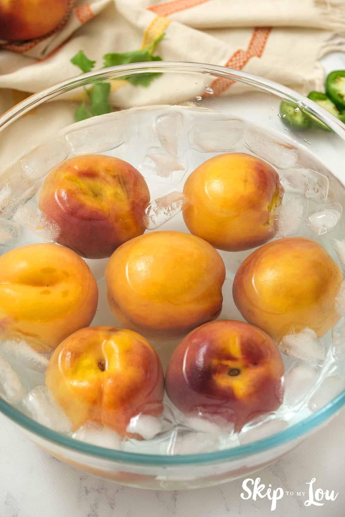 Peaches plunged into a bowl of ice water to loosen their skins for chopping for the Peach Salsa.