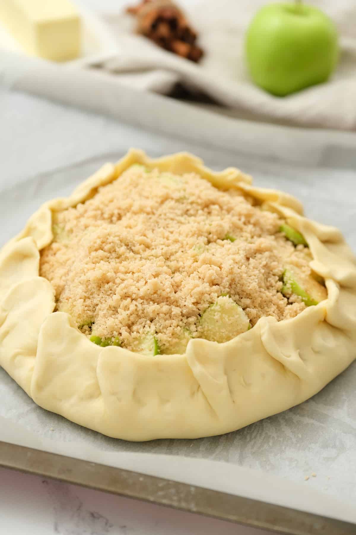 Pie dough folded up and pleated over the apple filling.