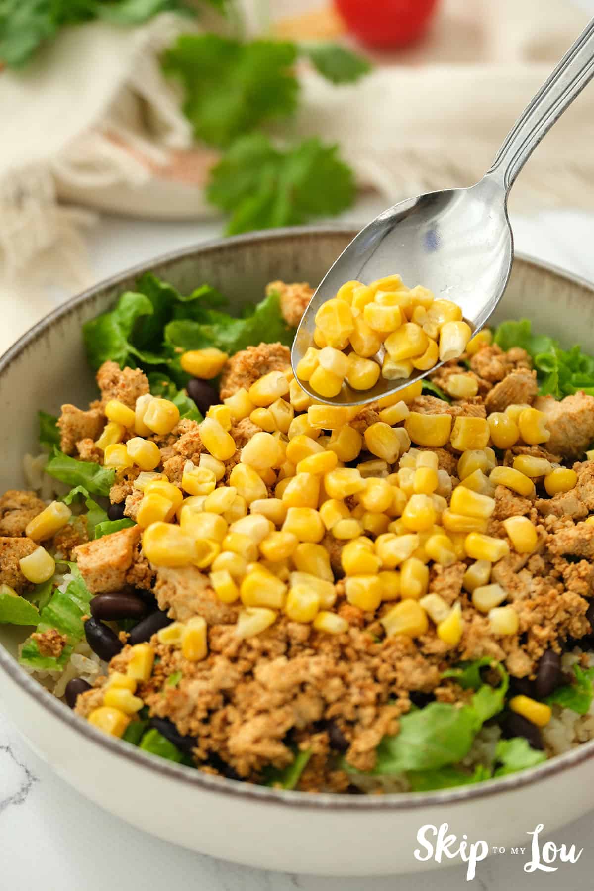 Adding the next layer of corn to the safritas bowl.