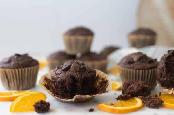 Image shows several chocolate muffins made with zucchini and orange. 