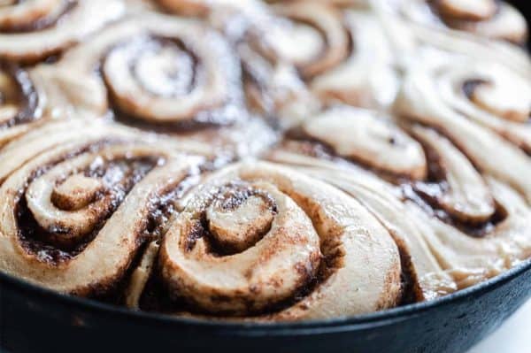 Image shows a closeup tray with baked sourdough cinnamon rolls.