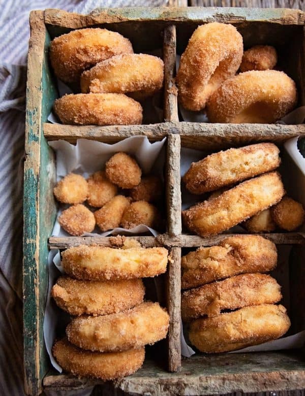 Image shows a batch of sourdough discard cinnamon sugar cake donuts. 