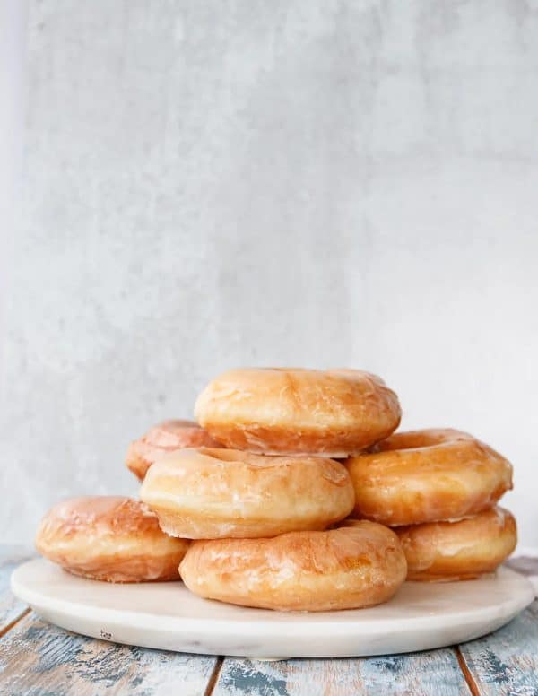 Image shows a batch of sourdough donuts piled on top of each other. 