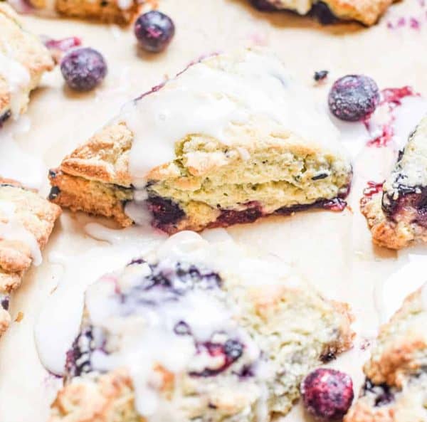 Image shows a slice of sourdough discard scones with blueberry and lemon