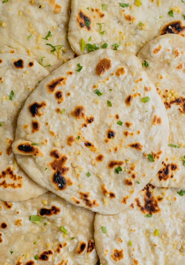 Image shows several naan breads made with sourdough discard.