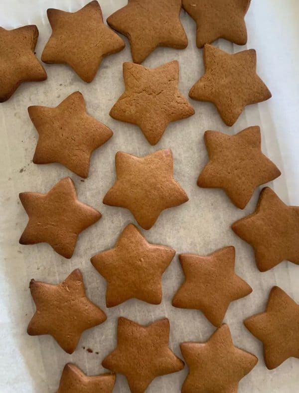 Image shows a batch of sourdough gingerbread cookies shaped like stars.