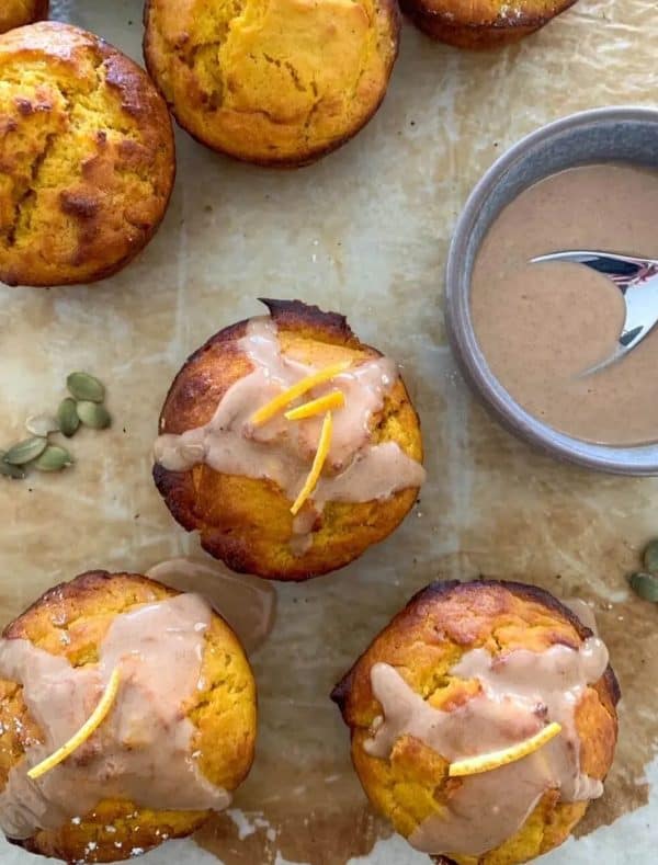 Image shows sourdough muffins with glaze on top, on a kitchen table.