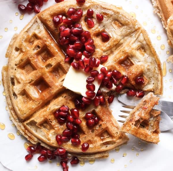 Image shows a sourdough waffle with pomegranate seeds on top.