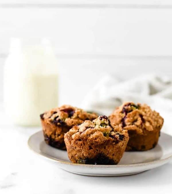 Image shows three bluebery muffins made with sourdough starter.
