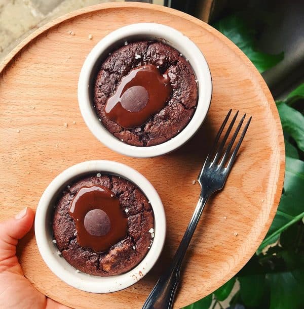 Image shows two sourdough discard chocolate mug cakes on a wood plate.