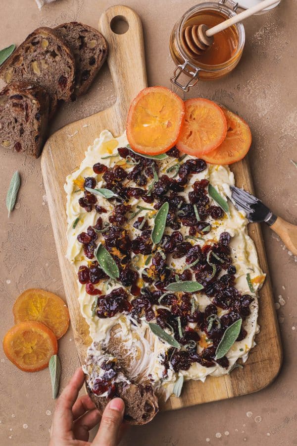 Image shows a fall-inspired butter board with oranges next to it for decoration and some slices of bread.