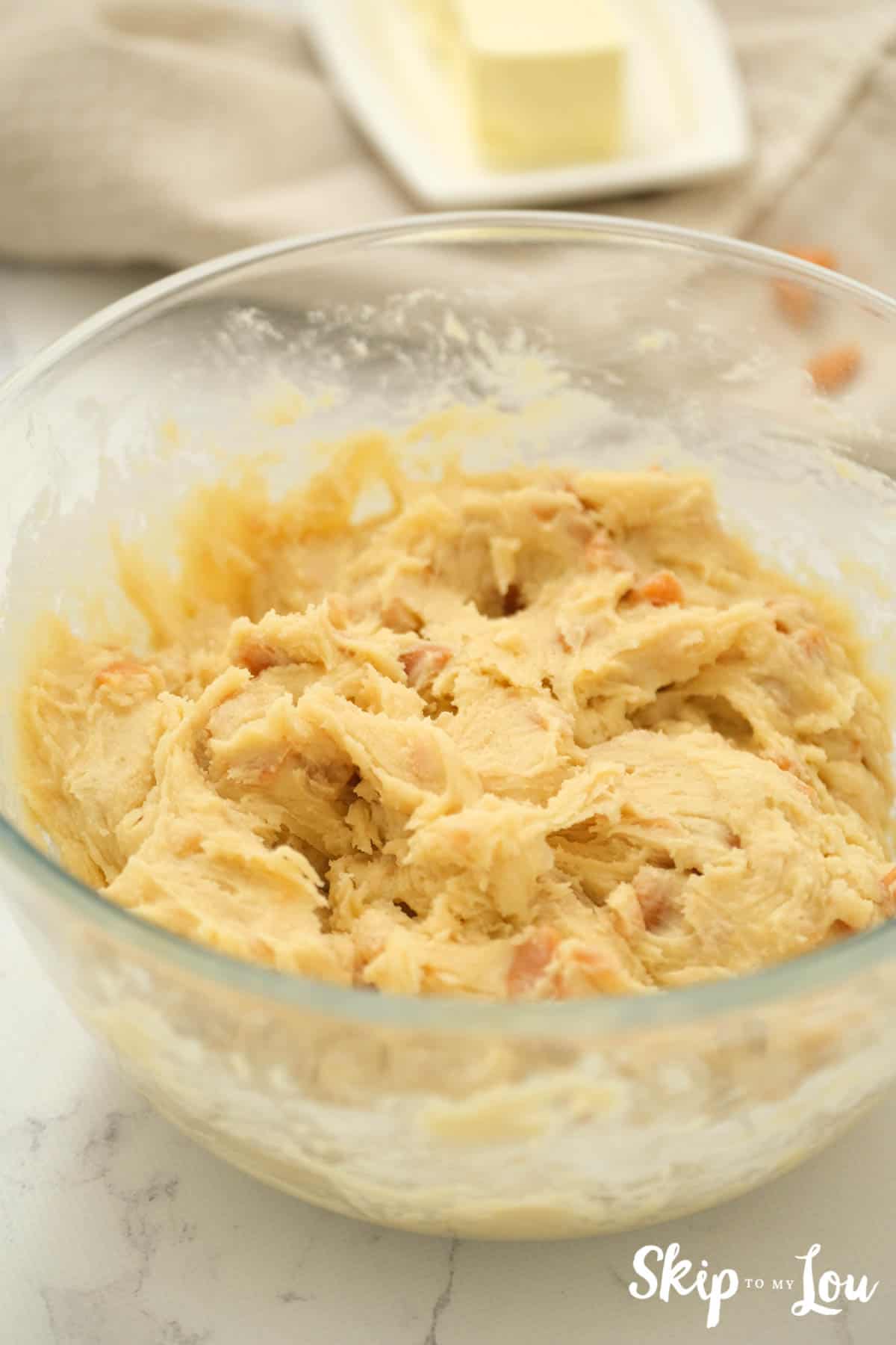 Large glass mixing bowl with batter for Toffee Doodle Cookies. -Skip To My Lou