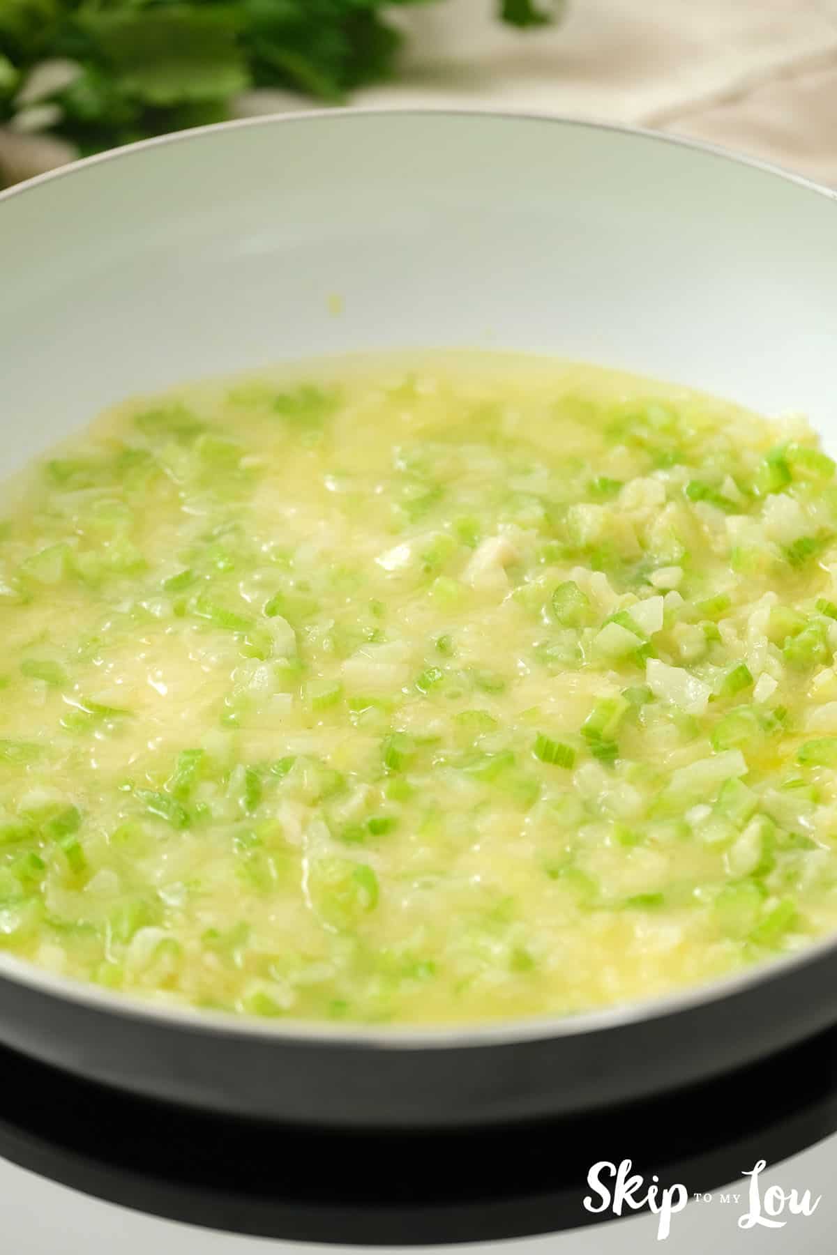 Onion and celery cooking in a large pan in butter.