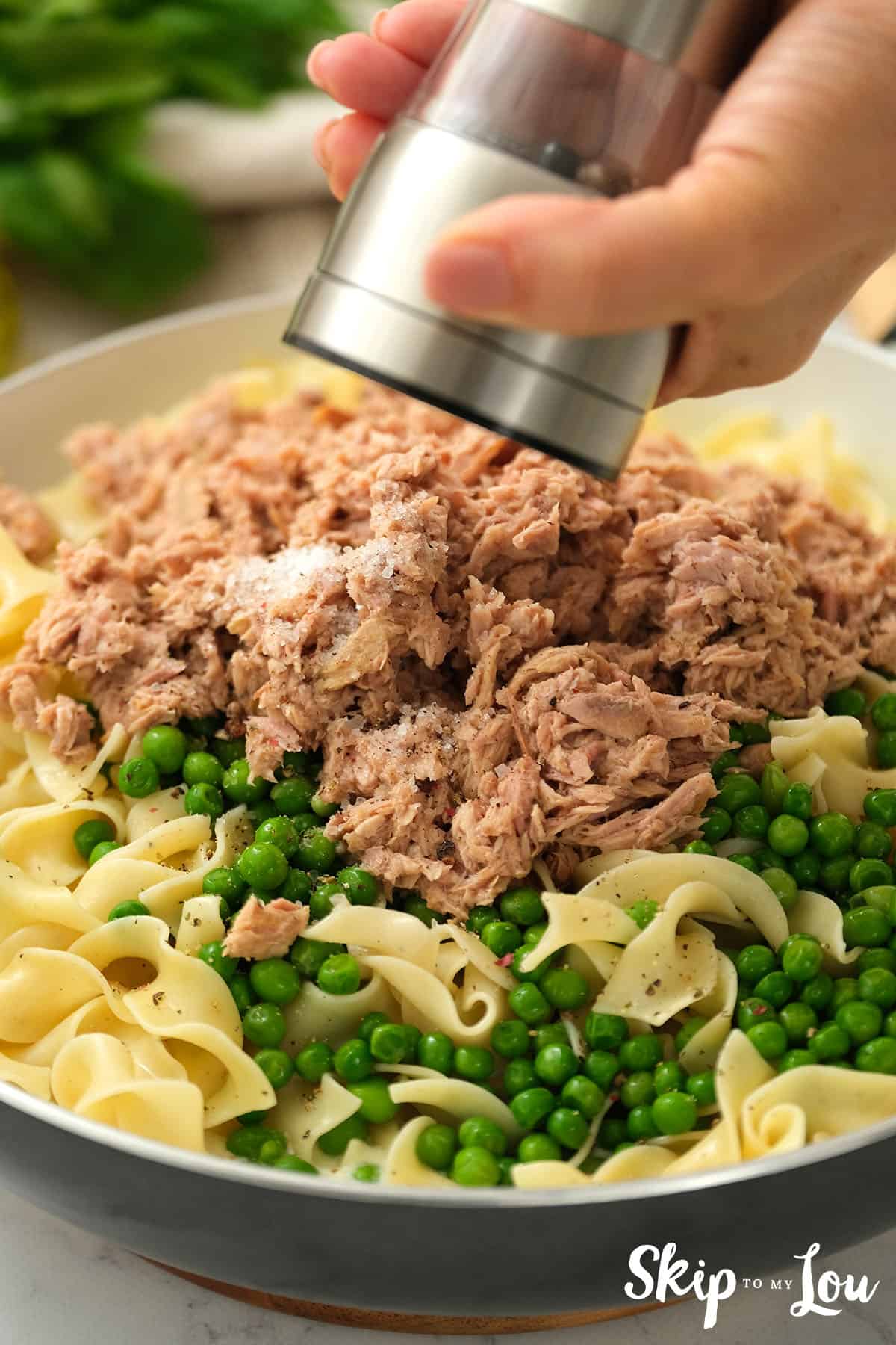Tuna, peas, and pasta stirred into the cream mixture with ground pepper as a garnish.