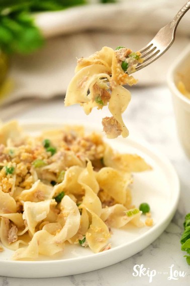Tuna Noodle Casserole served on a white dish with a bite on a fork.