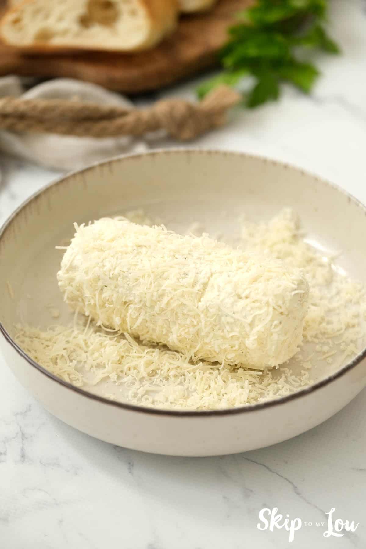 Herb butter spread in a dish rolled in grated parmesan. -Skip To My Lou