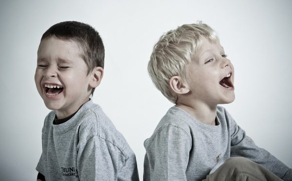 skip to my lou image of two kids facing away from each other laughing at kids jokes