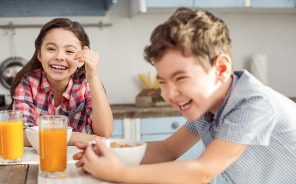 skip to my lou image of two kids at the breakfast table laughing at kids jokes