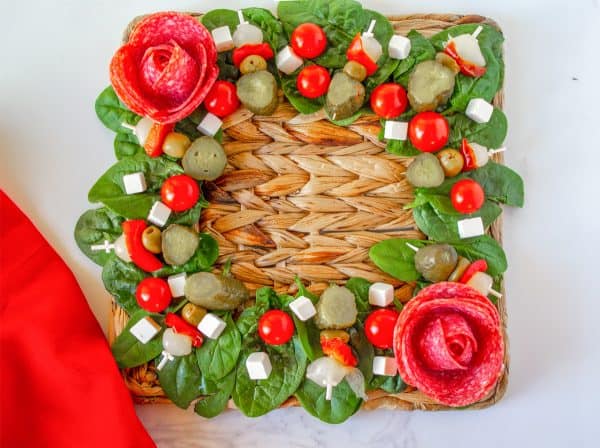 Image shows a charcuterie board in the shape of Christmas wreath with vegetables and salami. from Powered by mom.