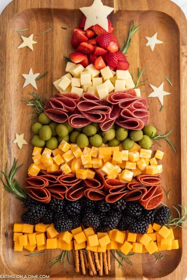 image shows a cheese board shaped like a christmas tree. it also has meats, blackberries and olives. via eating on a dime