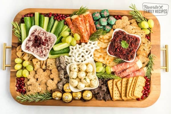 Image shows a christmas charcuterie board with pretzels, meats, gingerbread, cookies, and more. From Favorite family recipes