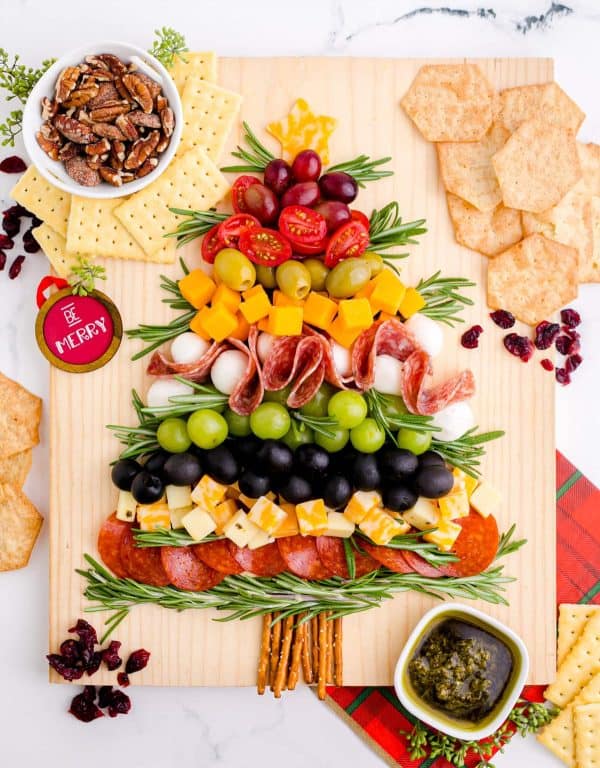 image shows a charcuterie board with vegetables and salami and cheese shaped like a Christmas tree. text reads Be merry. from kitchen fun with my 3 sons
