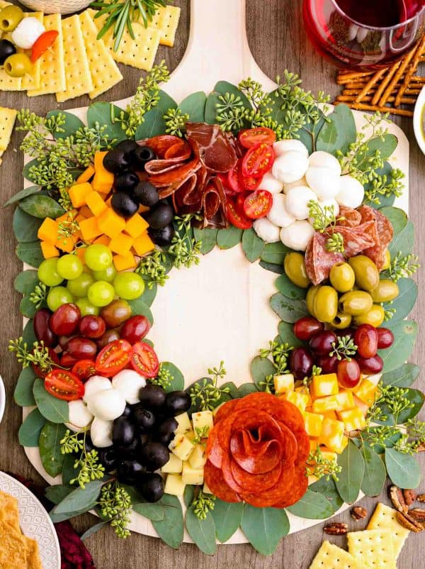 Imge shows a charcuterie board shaped like a christmas tree. via little sunny kitchen.
