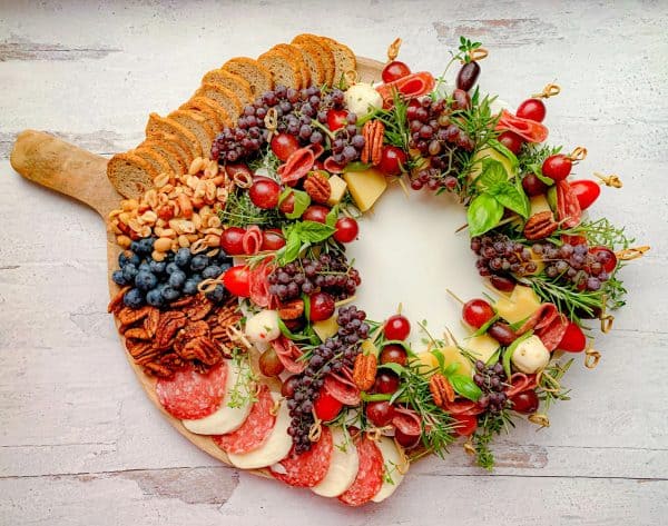 Image shows a charcuterie board with fresh herbs and dried fruits for a Christmas board. via not entirely average
