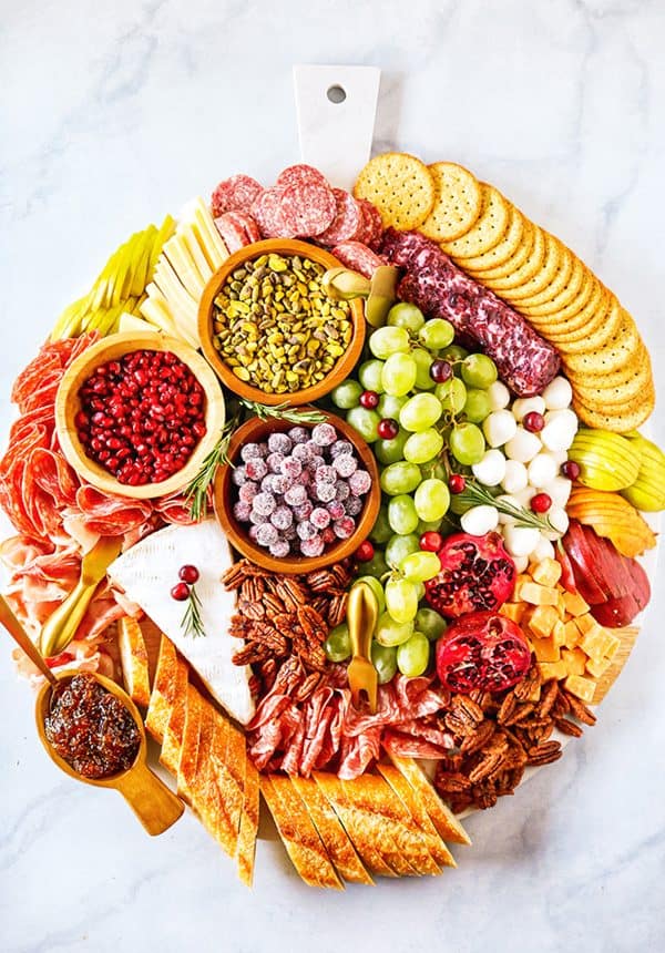Image shows a large Christmas charcuterie board with meats, nuts, fruits, breads, crackers and seeds. From number 2 pencil