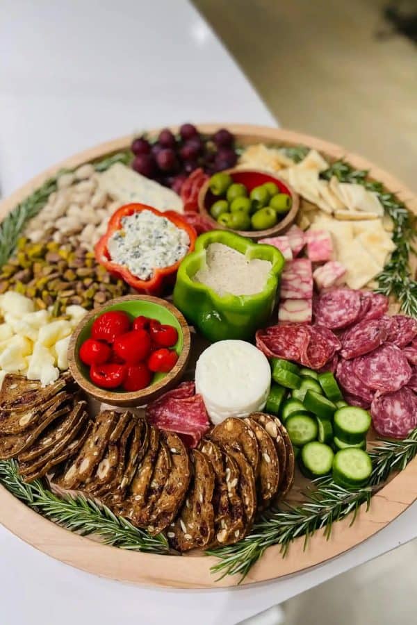 Image shows a charcuterie board with peppers filled with dip, meats, cheeses and vegetables. from Reluctant entertainer