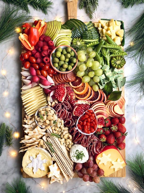 Image shows a charcuterie board with fruits and veggies, meats and nuts, from the delicious life
