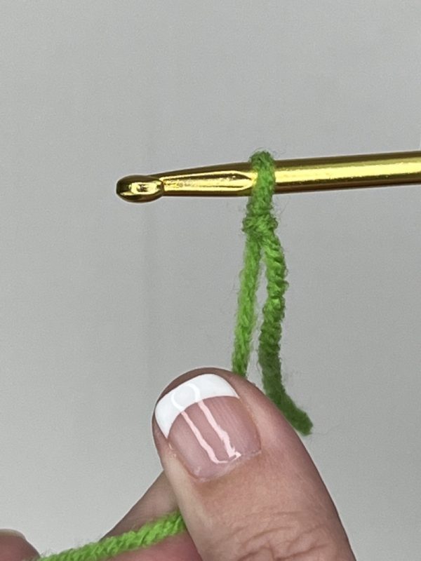 gently pull the yarn to tighten the knot against the hook