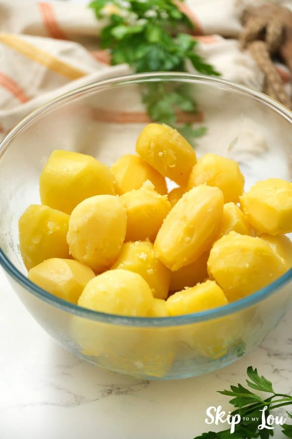 Potatoes peeled in a clear mixing bowl for the Instant Pot Mashed Potatoes. -Skip To My Lou
