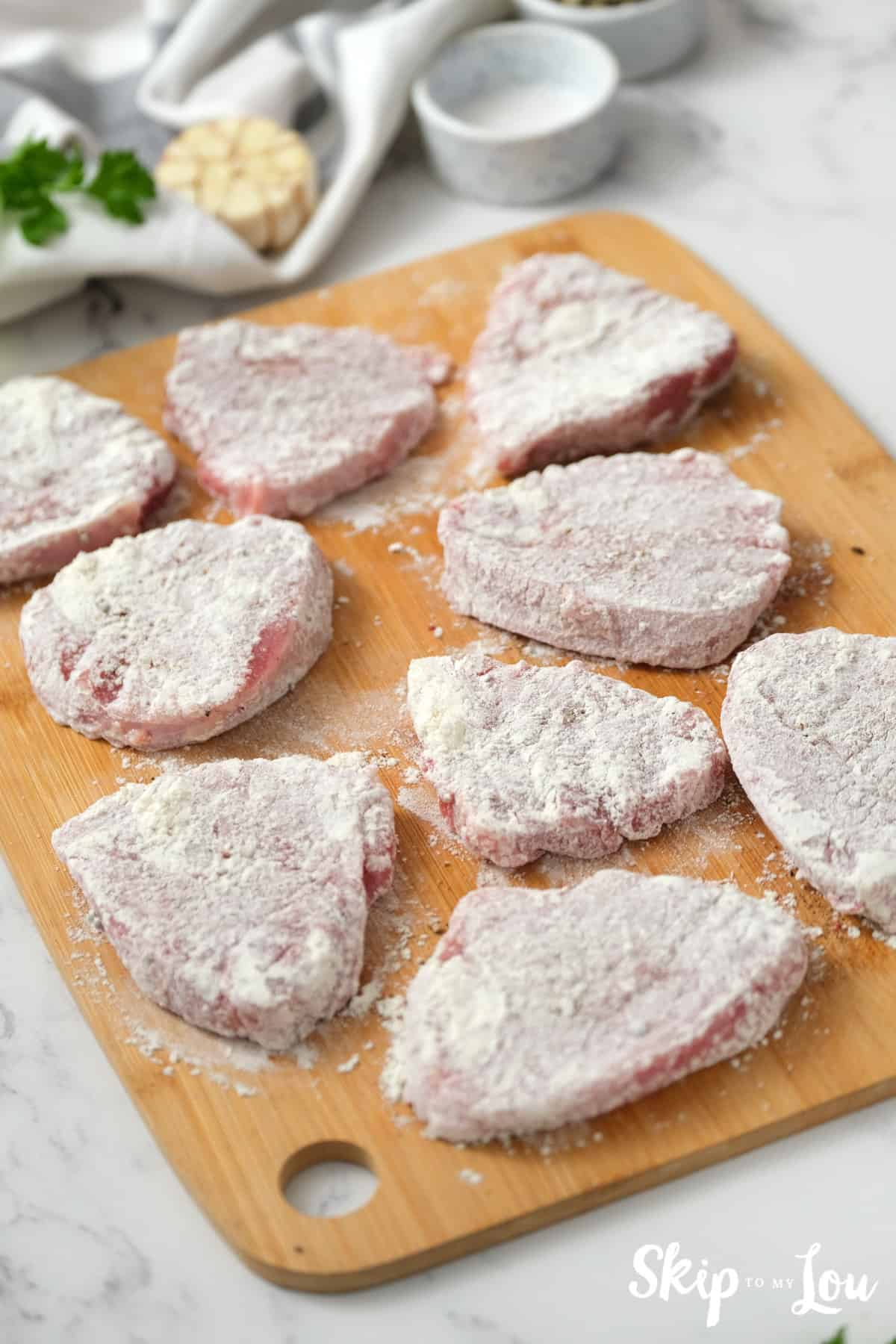 Bottom round steak slices that have been dredged in flour ready to be tenderized. Swiss Steak Recipe - Skip To My Lou
