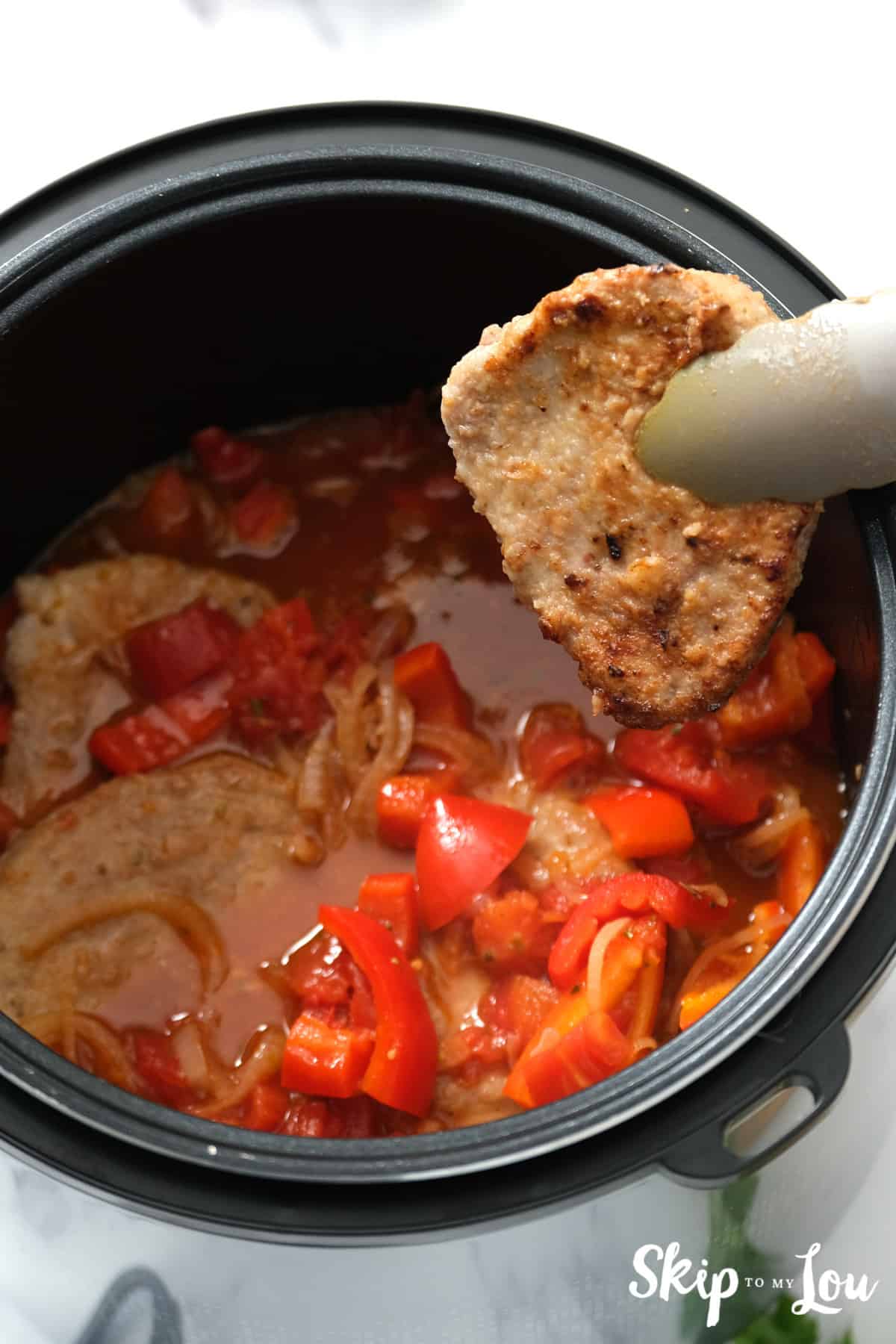 Steak being added to the vegetable mixture in the Instant Pot. Swiss Steak -Skip To My Lou